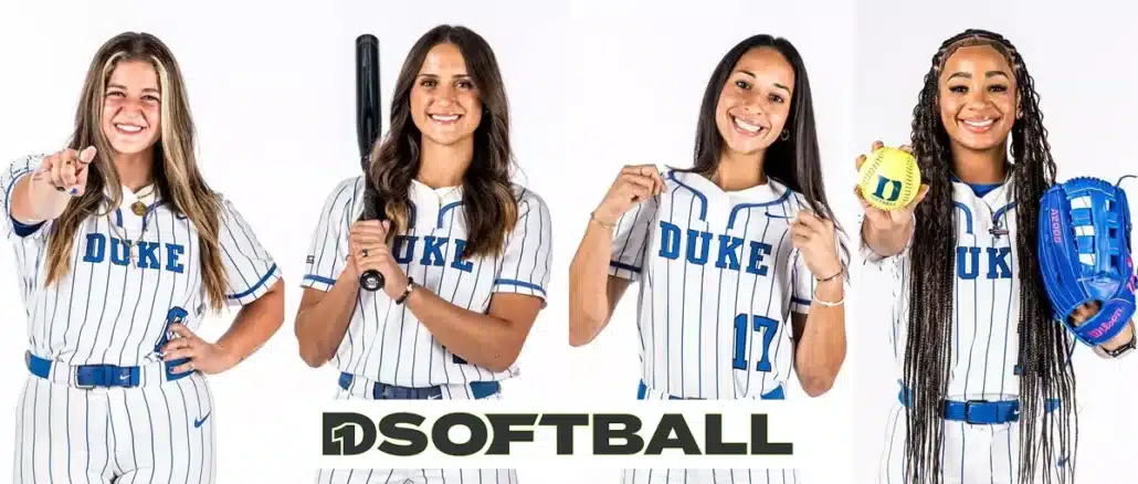 Four female softball players posing with bats indoors.