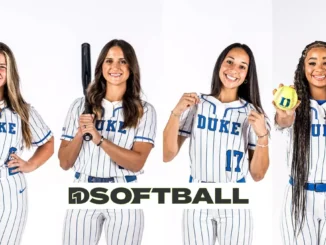 Four female softball players posing with bats indoors.